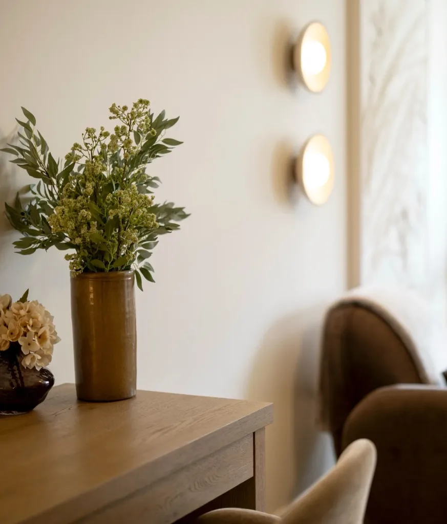 Therapy Room at London Bridge Therapy with two armchairs, soft wall lighting and fresh flowers on a wooden console table