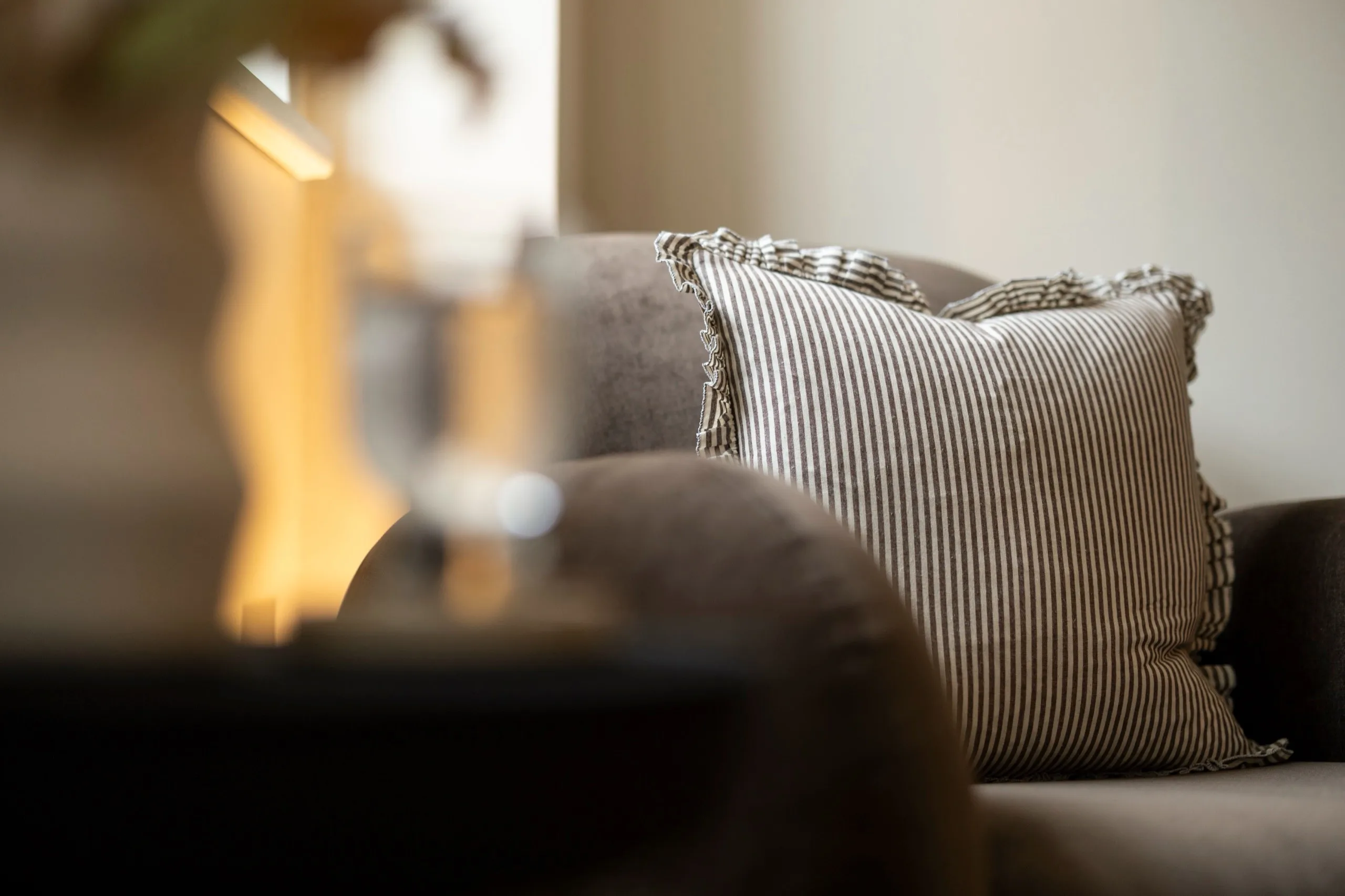 A striped cushion on a soft grey armchair in a calm therapy room at London Bridge Therapy
