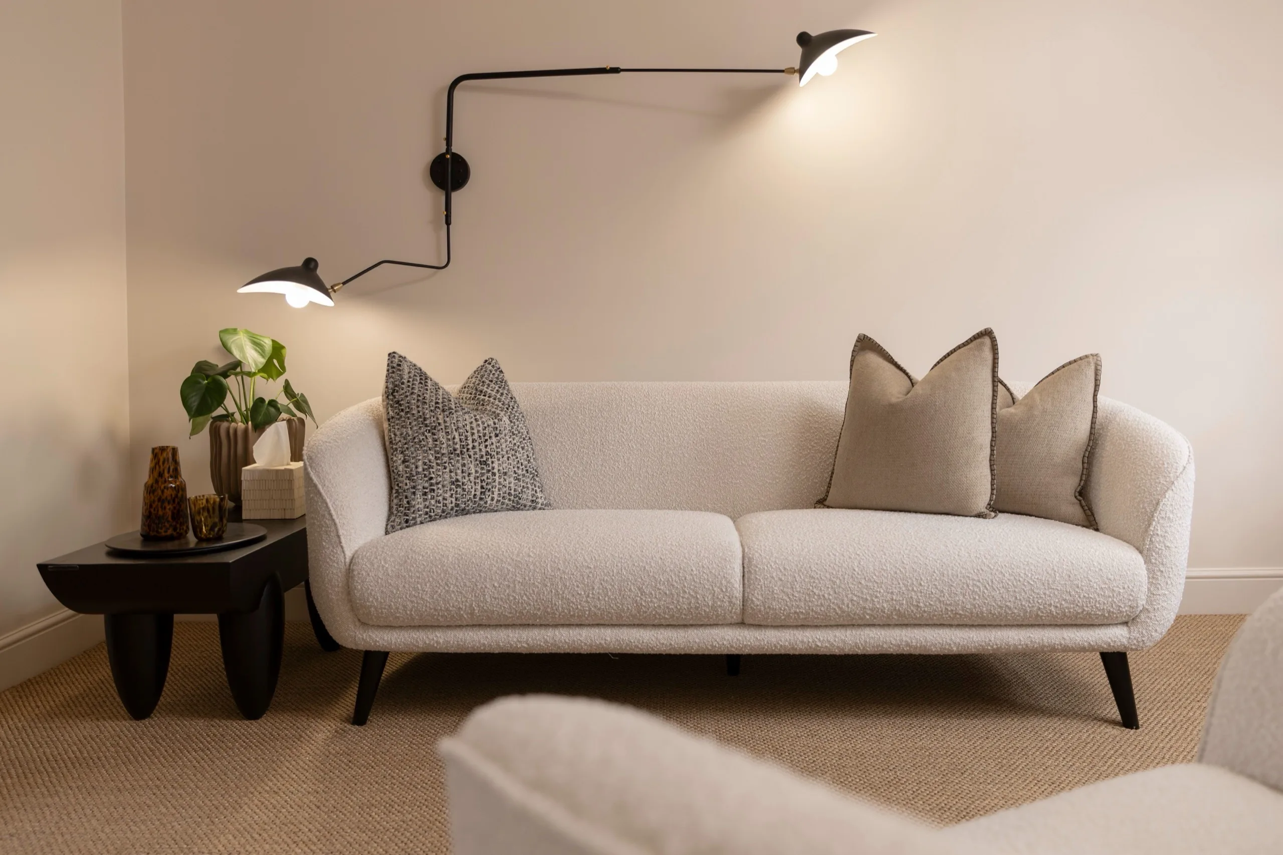 Sofa, side table and wall light in a therapy room at London Bridge Therapy in Borough
